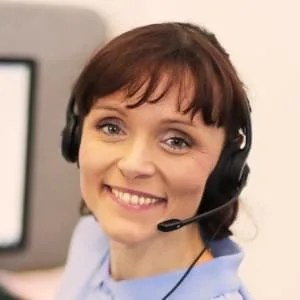 Kobieta z uśmiechem nosząca słuchawki z mikrofonem, pracująca w obsłudze klienta lub call center.